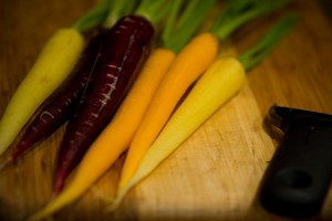 orange and purple carrots on a cutting board