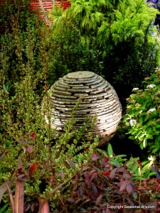 sleek water feature surrounded by evergreen plants