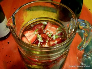 Delicious drink with herbs strawberries and edible flowers