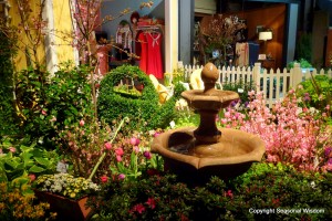 spring flowers and three-level fountain in romantic-style garden