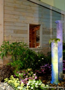 water columns that serve as fountains in beach-style garden