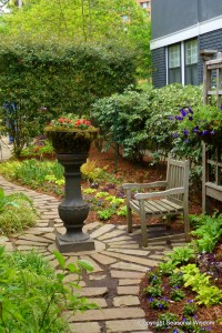 A decorative urn, brick pathway and sitting area are featured in this part of P. Allen Smith's garden.