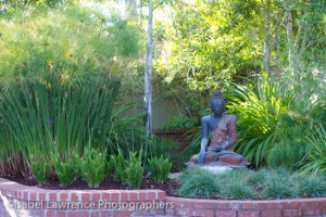 A four-foot Buddha in garden designed by Billy Goodnick.