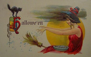 A witch flies on a broom in this vintage Halloween card