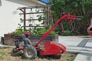 Troy-Bilt Bronco Axis rototiller by a vegetable garden