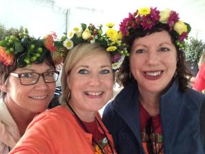 Three women wear flower wreaths at field to vase dinner with american grown flowers